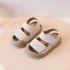 A pair of light beige toddler soft-soled sandals for boys and girls resting on a neutral background.