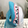 A blue shark-shaped board game toy featuring teeth and a snout, used for family fun.