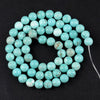 A strand of light blue sea sediment and turquoise beads arranged in a circular pattern for jewelry making