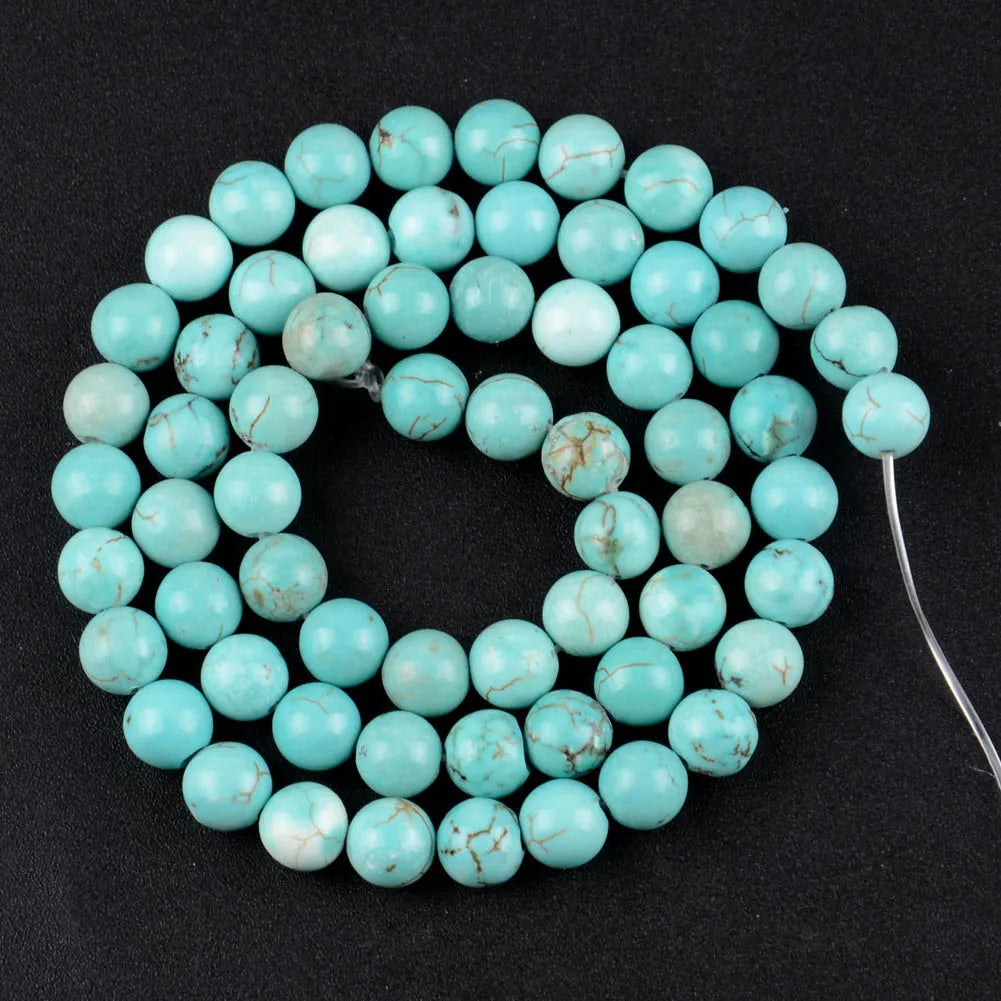 A strand of light blue sea sediment and turquoise beads arranged in a circular pattern for jewelry making