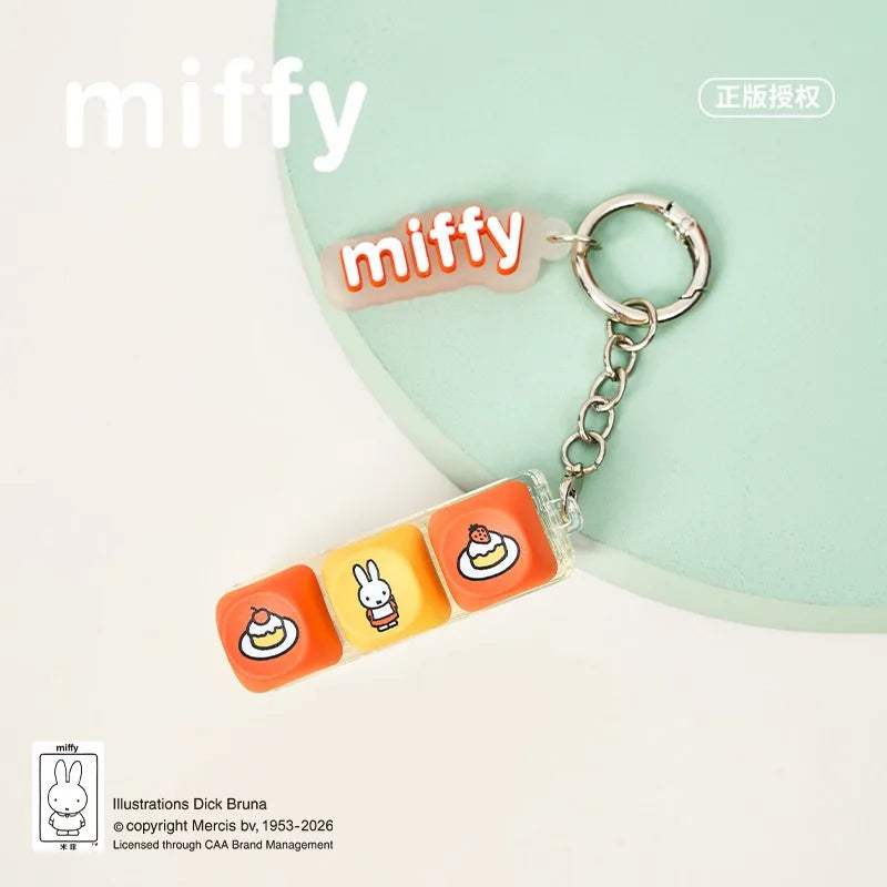 A Miffy keycap pendant keychain featuring three different character designs on an orange background.