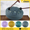 A portable 8-tone steel tongue drum with wooden mallets shown in various colors.