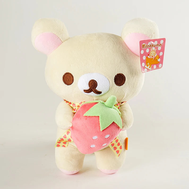 A fluffy white Rilakkuma bear plush toy with a pink strawberry accessory and a pink tag.