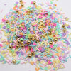 A pile of colorful polymer clay slices in various pastel shades including pink, purple, green, and yellow.