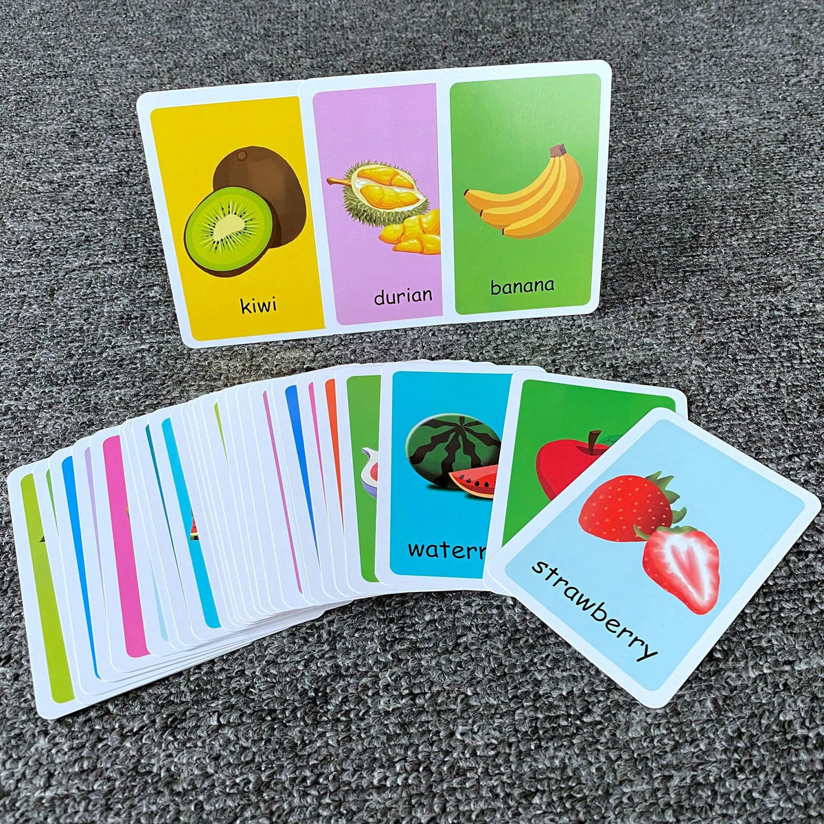A set of colorful flash cards showing various fruits including kiwi, durian, banana, watermelon, and strawberry.