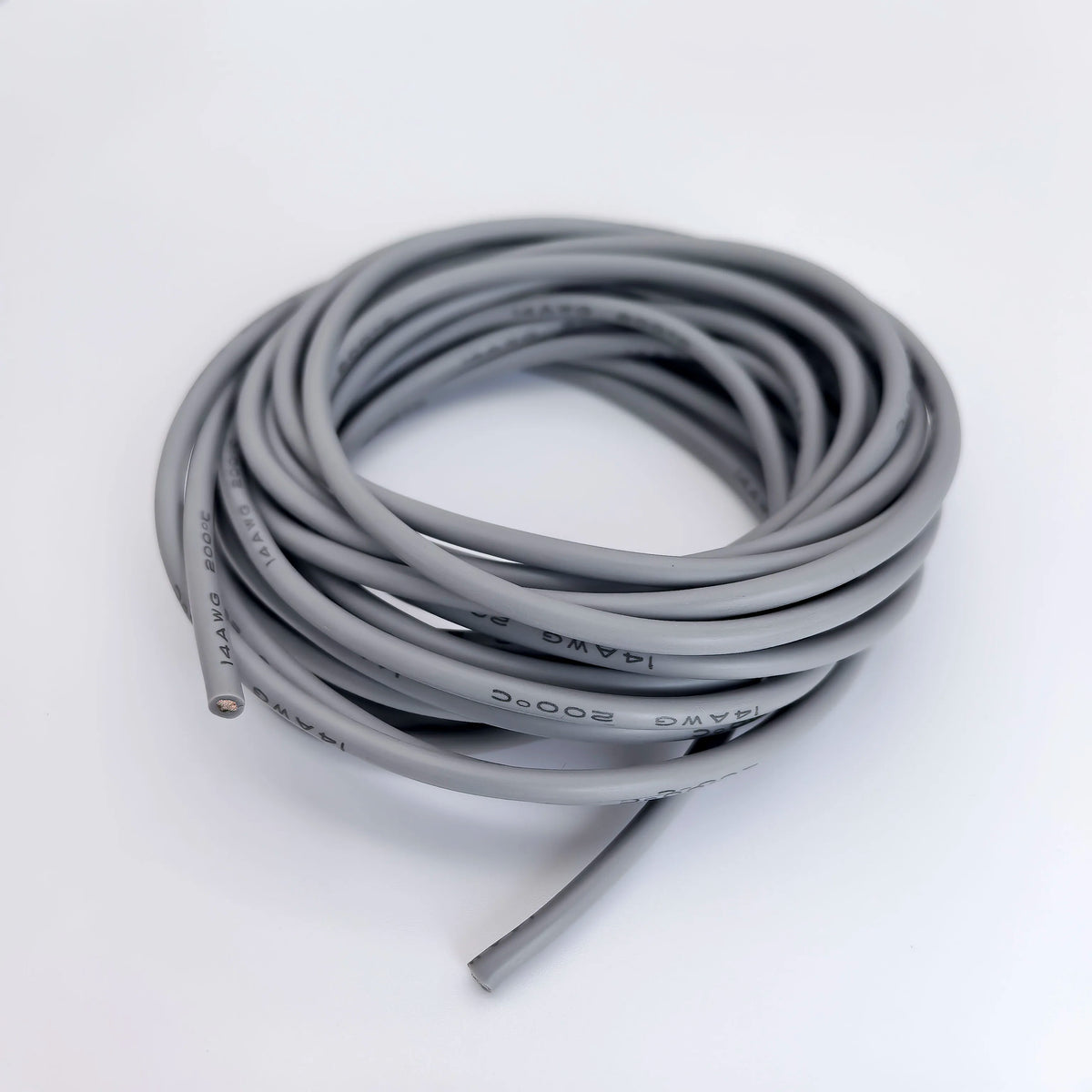 A coil of flexible silicone tinned copper wire in various AWG gauges, coiled on a white surface.
