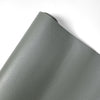 A close-up view of a gray PU leather material rolled up, showing the texture and finish.