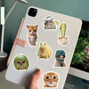 A collection of cute cat and animal stickers featuring various feline faces and animals on a white laptop surface.