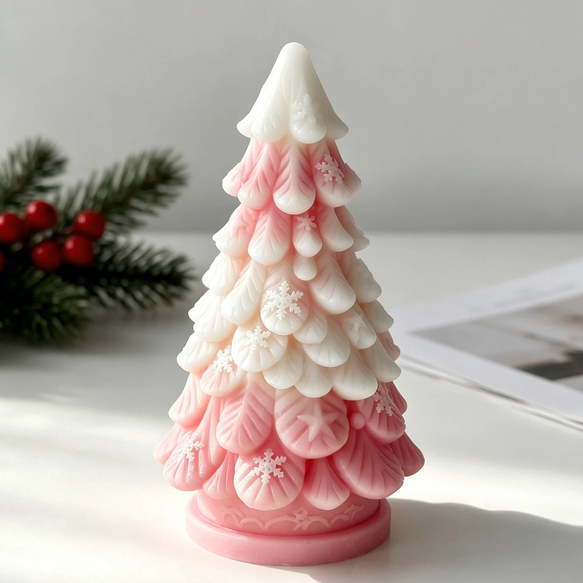 Pink silicone candle mold shaped like a Christmas tree with star and snowflake details.