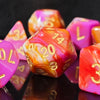A close-up of a set of seven polyhedral dice featuring swirling pink, orange, and red tones with gold numbering.