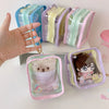 A collection of cute storage pouches and bags for dolls in pastel colors like pink, purple, and mint green.