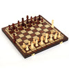 A wooden magnetic 3-in-1 chess, checkers, and backgammon set is displayed on a dark wooden board.
