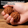 A hand holds two round, brown nuts used for relaxation and hand dexterity exercises.