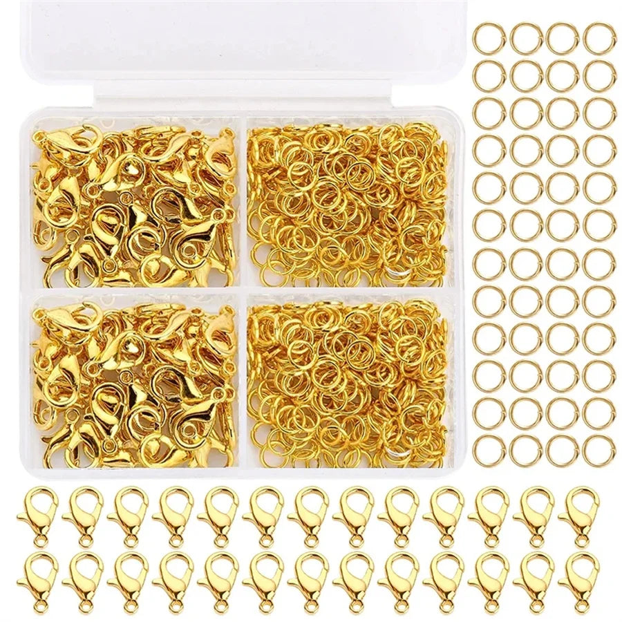 A clear plastic box filled with gold-colored lobster clasps and open jump rings for jewelry making