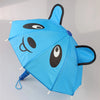 A bright blue fabric umbrella shaped like a horse, featuring black facial details and ears.