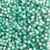 A close-up view of small, round, green glass crackle beads for jewelry making.