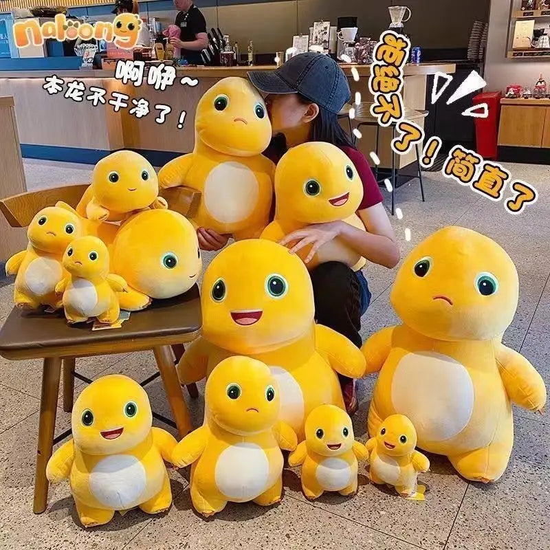 A collection of yellow and white milk dragon plush stuffed animals sitting on a wooden table.
