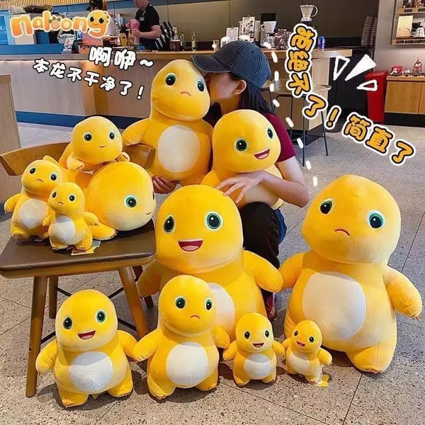 A collection of yellow and white milk dragon plush stuffed animals sitting on a wooden table.