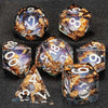 A collection of liquid core dice including d12s, d8s, and d6s, featuring gold flakes and iridescent colors.