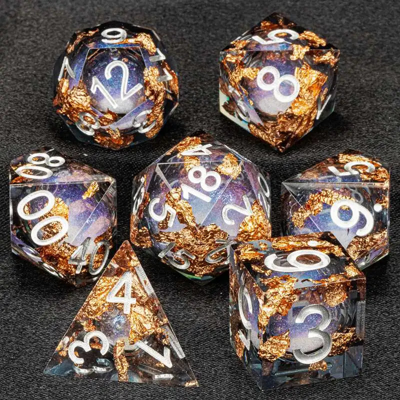 A collection of liquid core dice including d12s, d8s, and d6s, featuring gold flakes and iridescent colors.