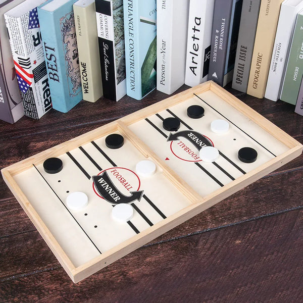 A wooden catapult tabletop hockey game with a wooden playing surface and black and white markings.