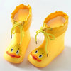 A pair of bright yellow kids rain boots with yellow laces and duck-shaped feet.