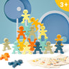 A collection of wooden balance stacking blocks in various colors and shapes arranged in a pyramid on a white surface.