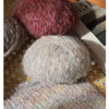 Two balls of soft alpaca blend yarn, one deep reddish-pink and one light gray, displayed next to a knitted swatch.