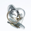 A clear silicone baby pacifier featuring a silver crown and the name Angelica spelled out in sparkling rhinestones.