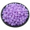 A pile of small, round, translucent purple acrylic beads for jewelry making.