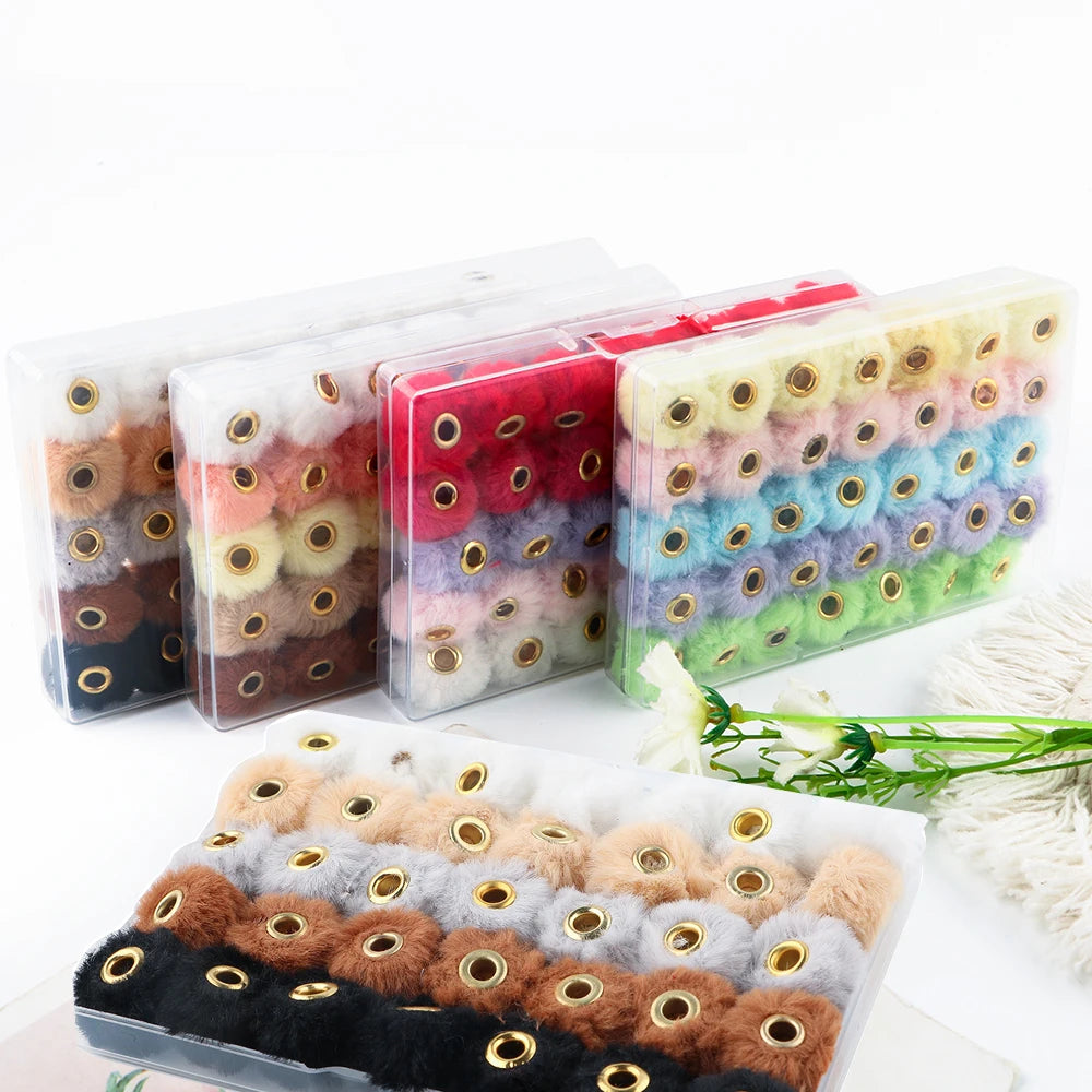 A collection of 35 plush fur pom pom beads in various colors and shades packaged in clear plastic.