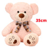 A pink teddy bear plush pillow with a brown nose and a plaid bow.