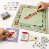 A green Monopoly board game is displayed next to a purple roulette wheel and small game pieces.
