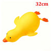 A yellow squishy toy shaped like a duck with orange feet and beak.