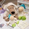 A plush toy of a brown wolf dressed in white sheep's clothing next to a blue sheep plush toy.
