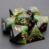 A pile of seven green resin polyhedral dice with gold markings resting on a dark surface.