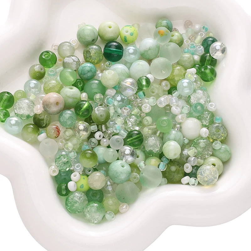 A pile of multicolored green and clear glass beads for jewelry making