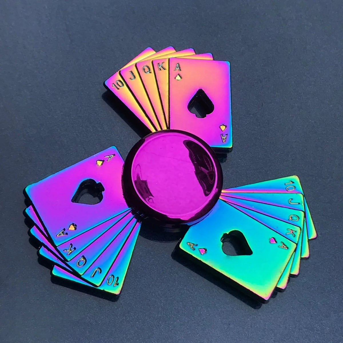 A fan of rainbow metal fidget spinners showing various card suits and numbers.