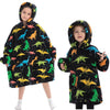 A young girl models a black flannel hoodie sweater with colorful dinosaur print.