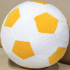 A white plush soccer ball toy with yellow hexagonal panels, shown from above.