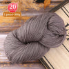 A ball of gray premium alpaca blend yarn used for knitting or weaving, displayed on a wooden surface.
