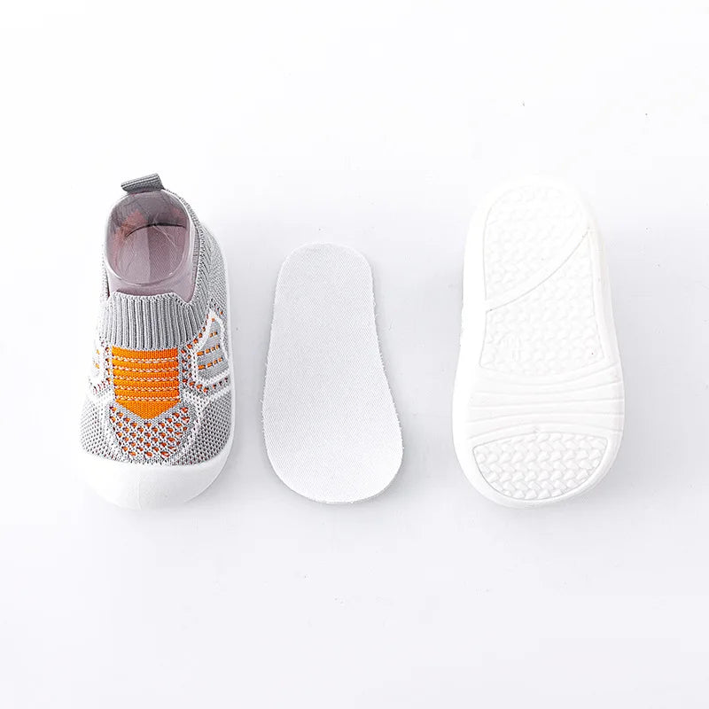 A pair of breathable anti-slip baby first walker shoes shown with the shoe and sole separated.