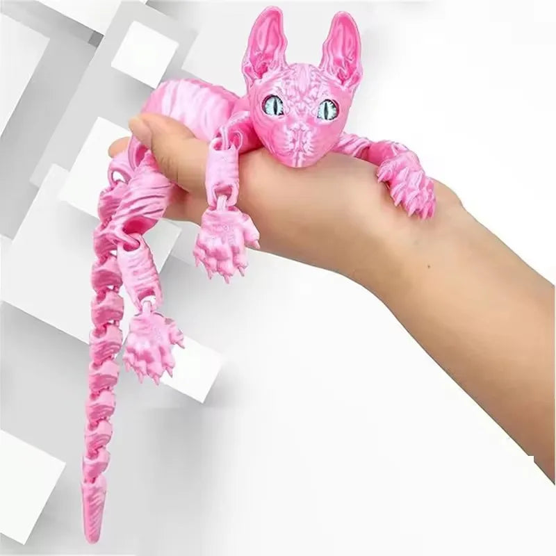 A hand is holding a pink articulated 3D printed sphynx cat figurine with large eyes and long pink limbs.