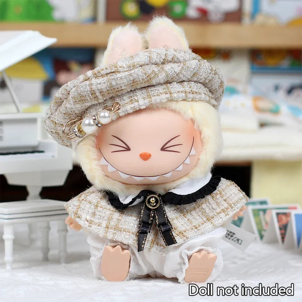 A cute rabbit doll wearing a beige tweed beret and matching cape set.