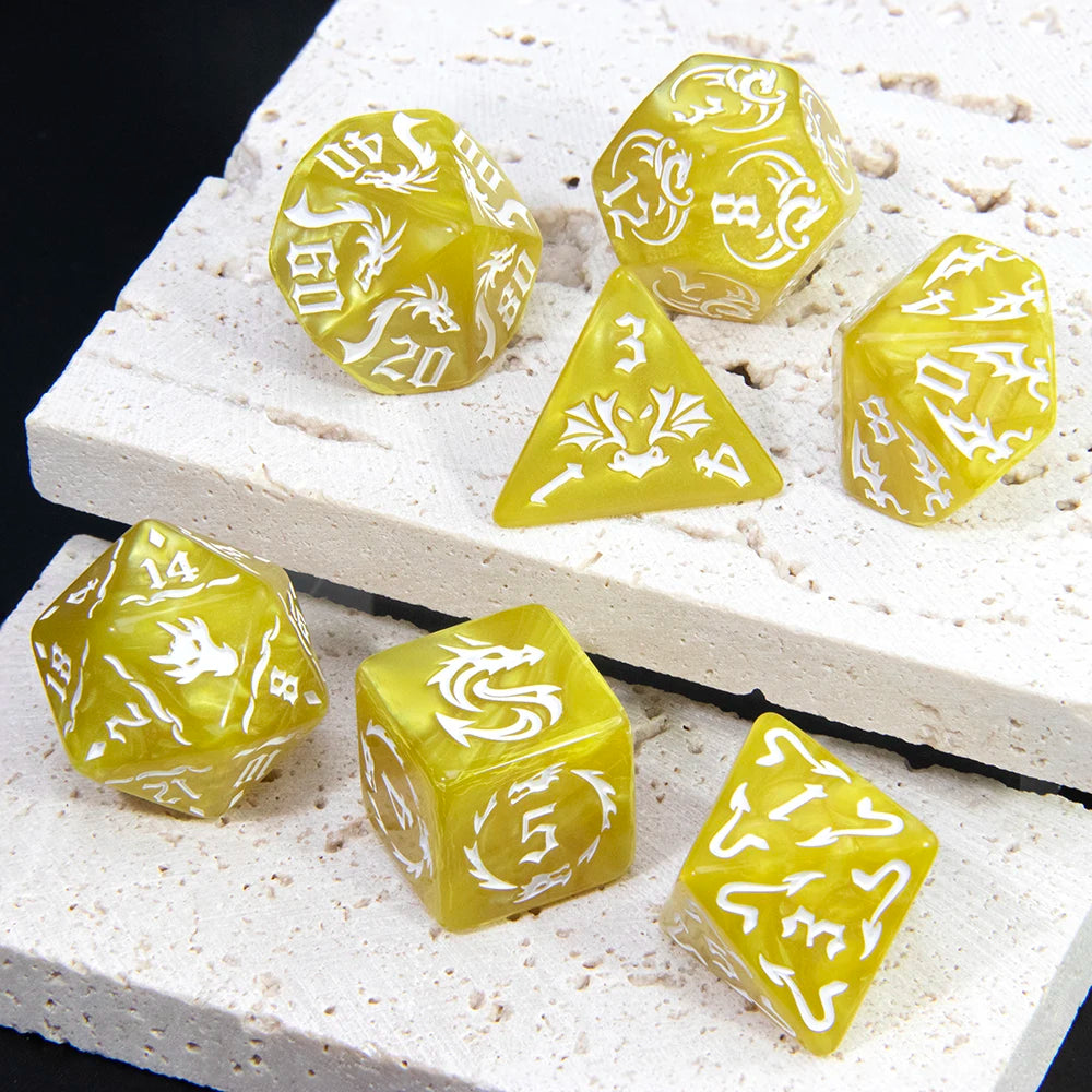 A set of yellow marble dragon pattern polyhedral dice resting on a white textured surface.