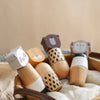 A collection of wooden animal puzzle toys, including a bear, lion, and elephant, resting on a beige fabric.