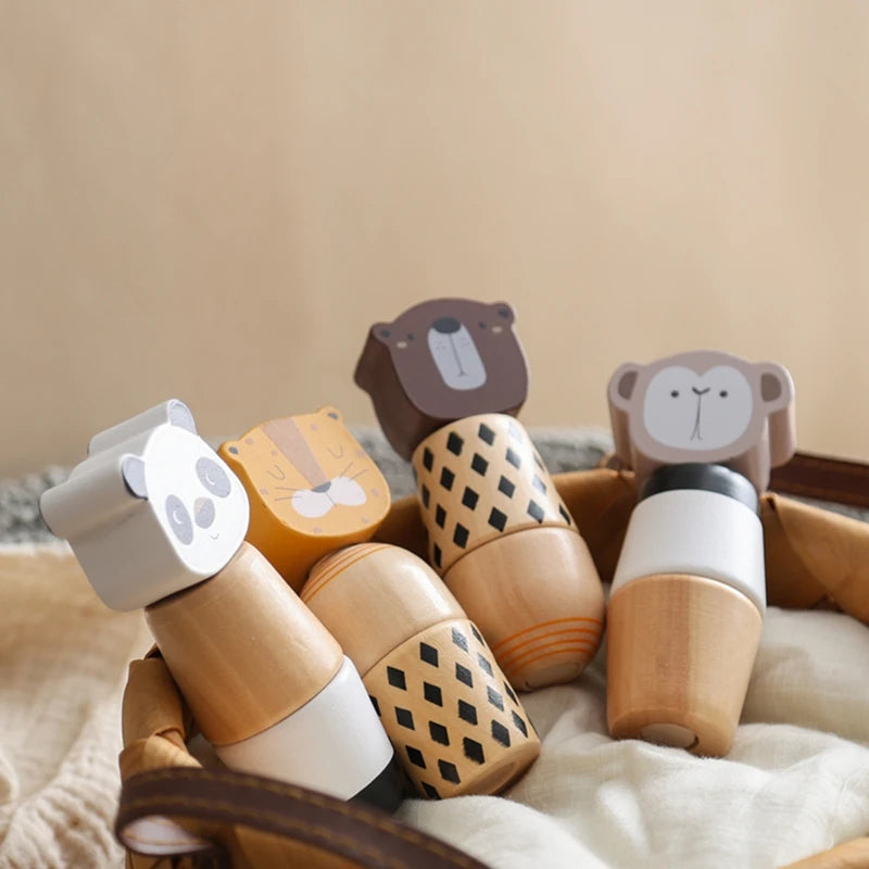 A collection of wooden animal puzzle toys, including a bear, lion, and elephant, resting on a beige fabric.