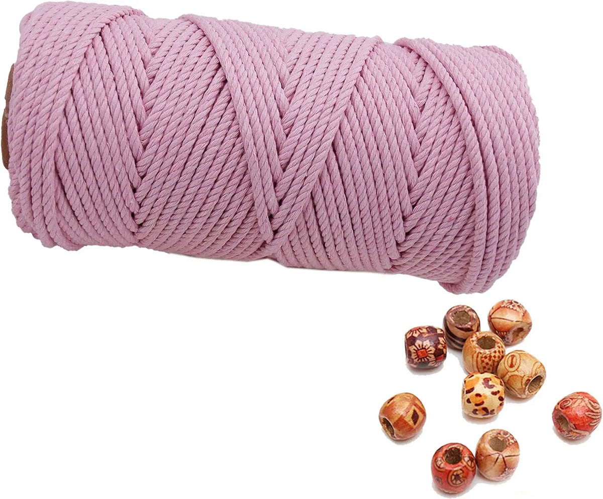 A spool of pink natural cotton macrame rope for crafts and decor.