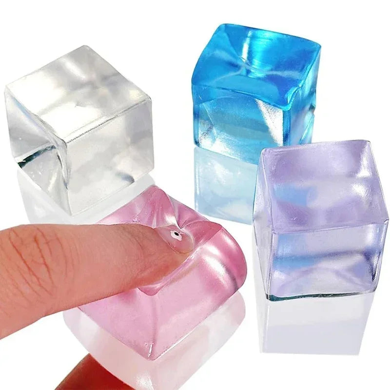 A hand is squeezing a pink ice cube squishy fidget toy next to blue and purple ice cubes.