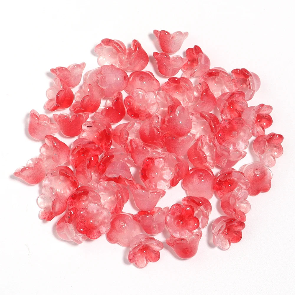 A pile of 50 glass beads shaped like cherry blossoms in shades of pink and red for jewelry making